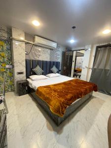 een slaapkamer met een groot bed en een bruine deken bij Kashi Dham Home Stay in Varanasi