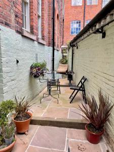 een patio met een tafel en stoelen en een bakstenen muur bij St. John’s hill - with parking in Shrewsbury