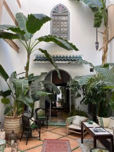 a living room with a lot of plants and tables at RIAD EN EXCLUSIVITE SUITE MEDINA BY DO in Marrakesh