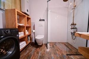 a bathroom with a washing machine and a toilet at FLH - Zen Apartment in Sibiu +16 photos