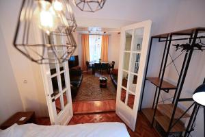 a bedroom with a bed and a living room with a table at FLH - Zen Apartment in Sibiu