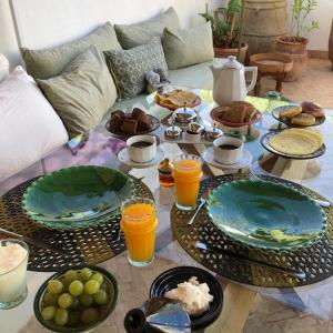 ein Tisch mit Tellern mit Essen und Getränken darauf in der Unterkunft RIAD EN EXCLUSIVITE SUITE MEDINA BY DO in Marrakesch
