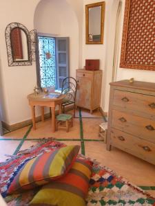 a living room with a table and a dresser and a window at RIAD EN EXCLUSIVITE SUITE MEDINA BY DO in Marrakesh