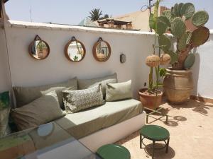eine Couch auf einer Terrasse mit Spiegeln und einem Kaktus in der Unterkunft RIAD EN EXCLUSIVITE SUITE MEDINA BY DO in Marrakesch