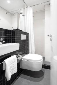 Hotel Tivoli Beira في بيرا: حمام اسود وبيض مع مرحاض ومغسلة