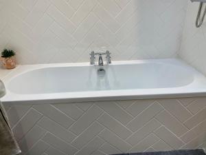 a white bath tub with a sink in a bathroom at St. John’s hill - with parking in Shrewsbury