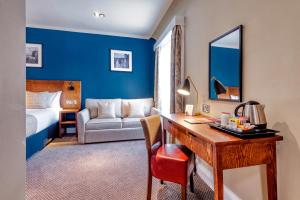 una camera d'albergo con scrivania e letto di Toby Carvery Edinburgh West by Innkeeper's Collection a Edimburgo