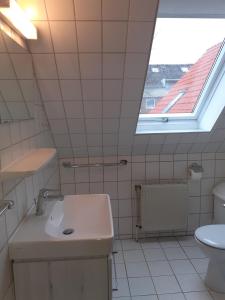 a white bathroom with a sink and a window at Haus Strandgang, Whg 4 in Kellenhusen