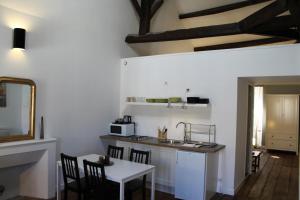 a kitchen with a sink and a table with chairs at Maison Charles Maurice in Chalais