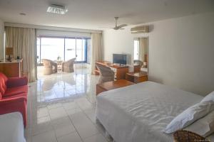 - une chambre avec un lit et un salon dans l'établissement Barracuda Eco Resort Búzios, à Búzios