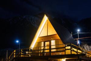 a large wooden building with a pointed roof at night at Cottage Nishi in Kazbegi