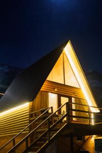 a house with a sloping roof with a staircase at Cottage Nishi in Kazbegi +33 photos
