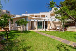 a large white house with a yard at Beach Front House Kalamaki Bungalow in Kato Galatas