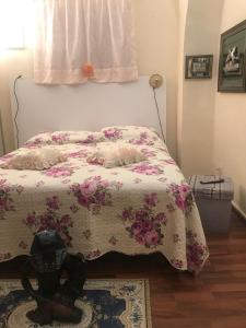 een slaapkamer met een bed met een bloemendeken bij Casa Vicolo del Poeta Acireale in Acireale