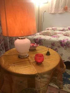 a lamp on a wooden table next to a bed at Casa Vicolo del Poeta Acireale in Acireale