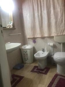 a bathroom with a sink and a toilet and a sink at Casa Vicolo del Poeta Acireale in Acireale