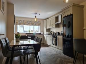 a kitchen with a table and chairs in a kitchen at The Manor Guest Accommodation Dungiven in Dungiven