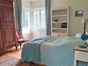 a bedroom with a bed and a chair and windows at Maison La Baule, 6 pièces, 8 personnes - FR-1-392-174 in La Baule