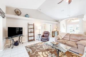 a living room with a couch and a tv at Life at the Canal in Cape Coral