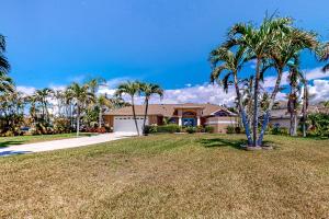 a large house with palm trees in a yard at Life at the Canal in Cape Coral