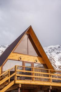 eine Blockhütte mit einem Gamerleich-Dach in der Unterkunft Cottage Nishi in Kazbegi