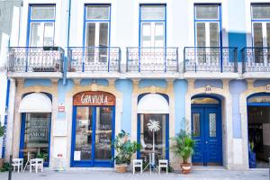 リスボンにあるLuxury Apartment near Cais do Sodréの青いドアとバルコニー付きの建物