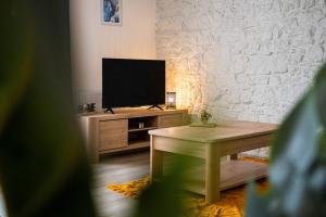 Televízia a/alebo spoločenská miestnosť v ubytovaní L'écrin authentique