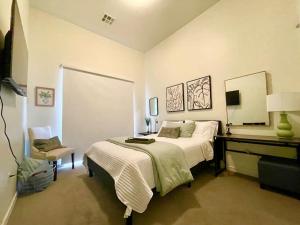 a bedroom with a bed and a desk with a mirror at A Perfect Getaway in the Heart of the Action in Las Vegas
