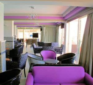 a room with purple chairs and tables and chairs at Akti Dimis Hotel in Tigaki