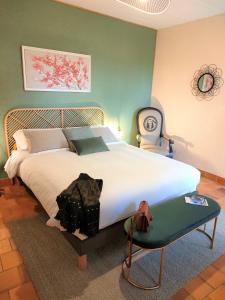 una camera da letto con un letto grande e una sedia di Terre et Eau La chambre d'hôtes du jardinier Sèvremont a Sevremont