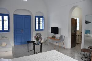 um quarto com portas azuis e uma mesa e cadeiras em Spacious veranda, house for 3, in the village. em Kamari