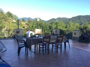 a table and chairs on a patio with mountains in the background at L'Angolo Divino in Casella