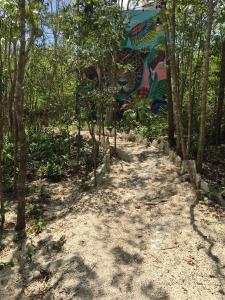 a path in the woods with a painting on a wall at Aldea Jaguar in Francisco Uh May