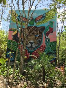 a mural of a leopard on the side of a building at Aldea Jaguar in Francisco Uh May
