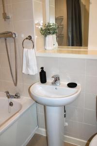 a bathroom with a sink and a toilet and a bath tub at Glamorous Two bed room flat in London