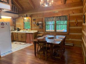 uma cozinha em madeira com uma mesa e um frigorífico em Bearadise Cabin em Terra Alta
