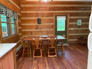 uma sala de jantar com uma mesa e cadeiras num camarote em Bearadise Cabin em Terra Alta