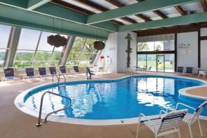 ein großer Pool in einem Hotel mit Stühlen drum herum in der Unterkunft Hueston Woods Lodge and Conference Center in Oxford