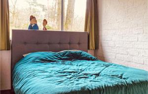 a bed with a blue comforter in a bedroom at Beautiful stacaravan In Rheezerveen With Kitchen in Rheezerveen