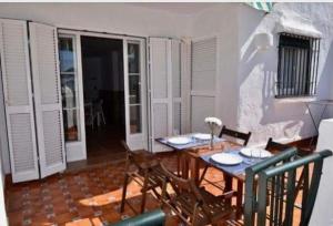 uma sala de jantar com uma mesa de madeira e cadeiras em Apartamento La Barrosa em Chiclana de la Frontera