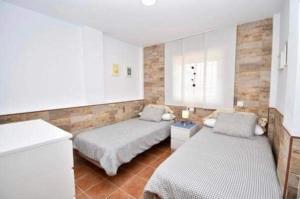 a bedroom with two beds and a counter in it at Apartamento La Barrosa in Chiclana de la Frontera