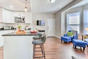 a kitchen and living room with a counter and chairs at Newly Renovated, Quaint, Modern 2-Bedroom Loft in Front Royal