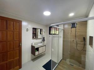a bathroom with a glass shower and a sink at Confortável Chalet na Serra proximo ao Centro in Nova Friburgo +66 photos