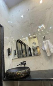 een badkamer met een stenen wastafel en een spiegel bij Kashi Dham Home Stay in Varanasi