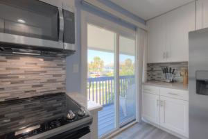 a kitchen with a stove and a balcony at Sandy Feet Retreat 4 Oceanview Balconies Pets Ok in Jacksonville Beach