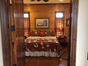 Suite Sweetheart A Mountain Escape في Mentone: غرفة نوم بسرير في غرفة بجدران خشبية