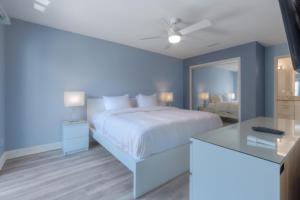 a bedroom with a white bed and a blue wall at Sandy Feet Retreat 4 Oceanview Balconies Pets Ok in Jacksonville Beach