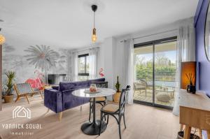 - un salon avec un canapé bleu et une table dans l'établissement L'ORMEAU FLAMINGO, à Toulouse