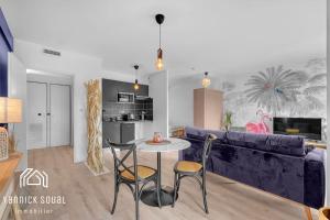 een woonkamer met een bank en een tafel en stoelen bij L'ORMEAU FLAMINGO in Toulouse