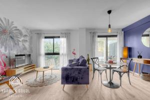 a living room with a blue couch and a table at L'ORMEAU FLAMINGO in Toulouse